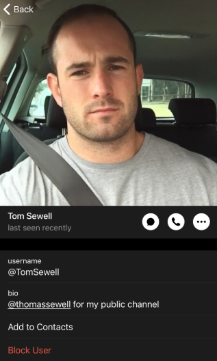 Screenshot of a Telegram profile page for "Tom Sewell" (@TomSewell), showing status "last seen recently." Profile picture shows a man with short dark hair and light stubble sitting in a car wearing a gray t-shirt with a seatbelt across his chest. Bio reads "@thomassewell for my public channel." Interface includes camera, phone, and menu icons, plus "Add to Contacts" and "Block User" buttons.